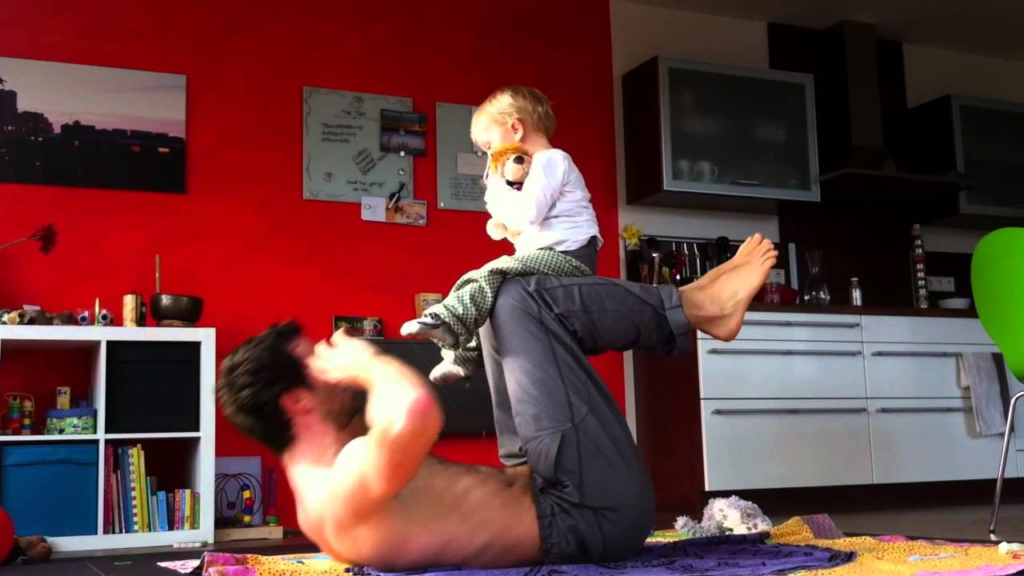 Young kid learning exercise from father
